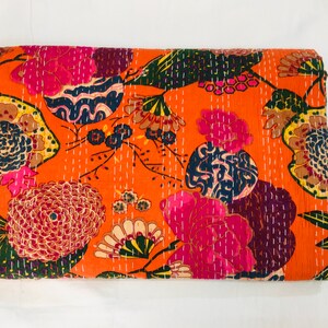 Peut inclure: Une courtepointe kantha avec un motif floral dans des tons de rose, orange, vert et bleu. La courtepointe est en coton et pr&eacute;sente un design cousu &agrave; la main.