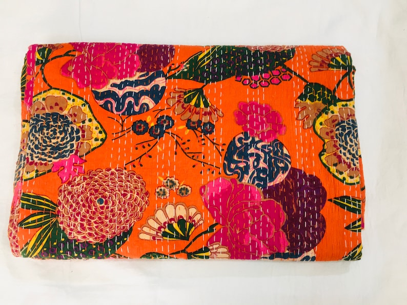 Peut inclure: Une courtepointe kantha avec un motif floral dans des tons de rose, orange, vert et bleu. La courtepointe est en coton et pr&eacute;sente un design cousu &agrave; la main.
