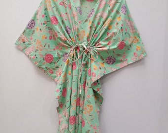 May include: A green cotton kaftan with a floral print. The kaftan has a V-neck and a tie at the waist.
