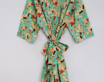 May include: A turquoise kimono-style robe with a floral and crane pattern. The robe features a tie closure and white trim. The design includes red, yellow, and white flowers and cranes. The robe is hanging on a black hanger.