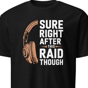Może przedstawiać: Czarny t-shirt z jasnobrązową grafiką słuchawek i białym napisem "SURE RIGHT AFTER THIS RAID THOUGH". Koszulka wykonana jest z miękkiego materiału. Codzienna koszulka.