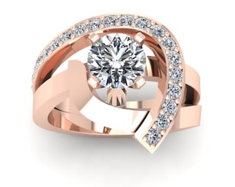 May include: A rose gold engagement ring with a large round center diamond and a halo of smaller diamonds. The band is a double band with a unique design.