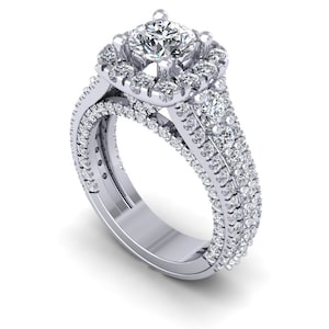 May include: A silver engagement ring with a large, square-cut diamond surrounded by a halo of smaller diamonds. The band is adorned with a double row of smaller diamonds.