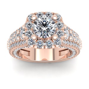 May include: A rose gold engagement ring with a large, round center diamond surrounded by a halo of smaller diamonds. The band is also set with smaller diamonds.