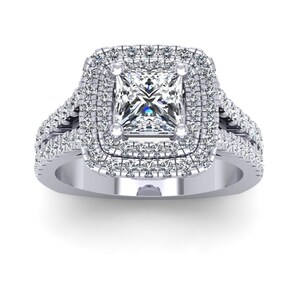 May include: A silver engagement ring with a square-shaped center diamond surrounded by two rows of smaller diamonds. The band is also set with diamonds.