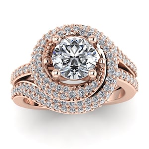 Puede incluir: Un anillo de compromiso de oro rosa con un gran diamante redondo central rodeado por un doble halo de diamantes más pequeños. La banda también está engastada con diamantes más pequeños y tiene un diseño retorcido.