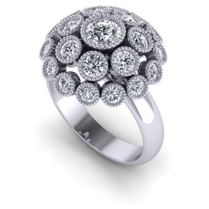 May include: A silver ring featuring a cluster of round, brilliant-cut diamonds. The diamonds are set in individual bezels, creating a dome-like appearance. The ring's band is smooth and polished, with a high-shine finish.