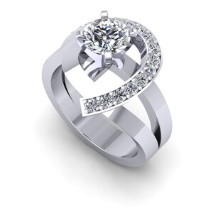 May include: A silver ring with a large round diamond in the center and smaller diamonds set in a curved band around the center stone.