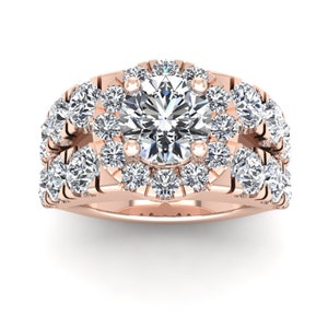 May include: A rose gold engagement ring with a large round center stone surrounded by a halo of smaller diamonds. The band is also set with smaller diamonds.