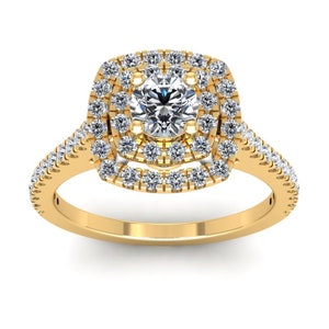 Puede incluir: Un anillo de compromiso de oro con un gran diamante redondo central rodeado de dos filas de diamantes más pequeños. La banda también está engastada con diamantes.