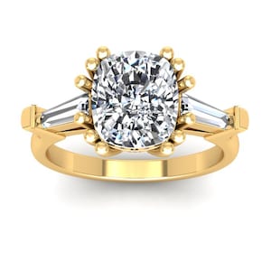 May include: A gold engagement ring with a large cushion-cut diamond center stone and two smaller baguette-cut diamonds on either side.