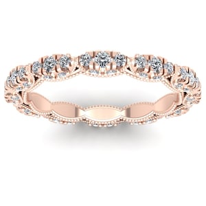 Puede incluir: Anillo de oro rosa con un diseño delicado. El anillo presenta una serie de pequeños diamantes brillantes engastados a lo largo de la banda. La banda tiene un intrincado patrón de estilo filigrana con pequeños detalles de cuentas. Una joya clásica.