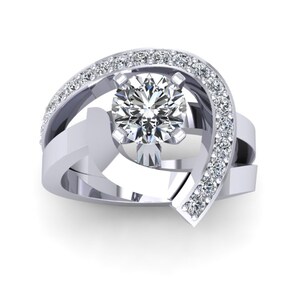 May include: A silver engagement ring with a large round center diamond and smaller diamonds set in a curved band.