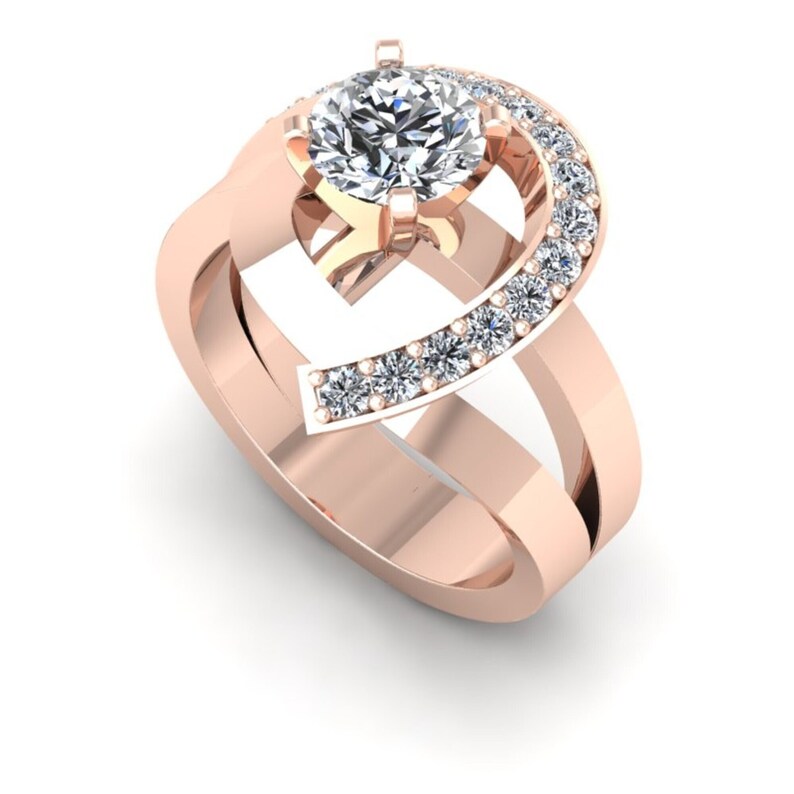 May include: A rose gold engagement ring with a large round center diamond and a crescent shaped band of smaller diamonds.