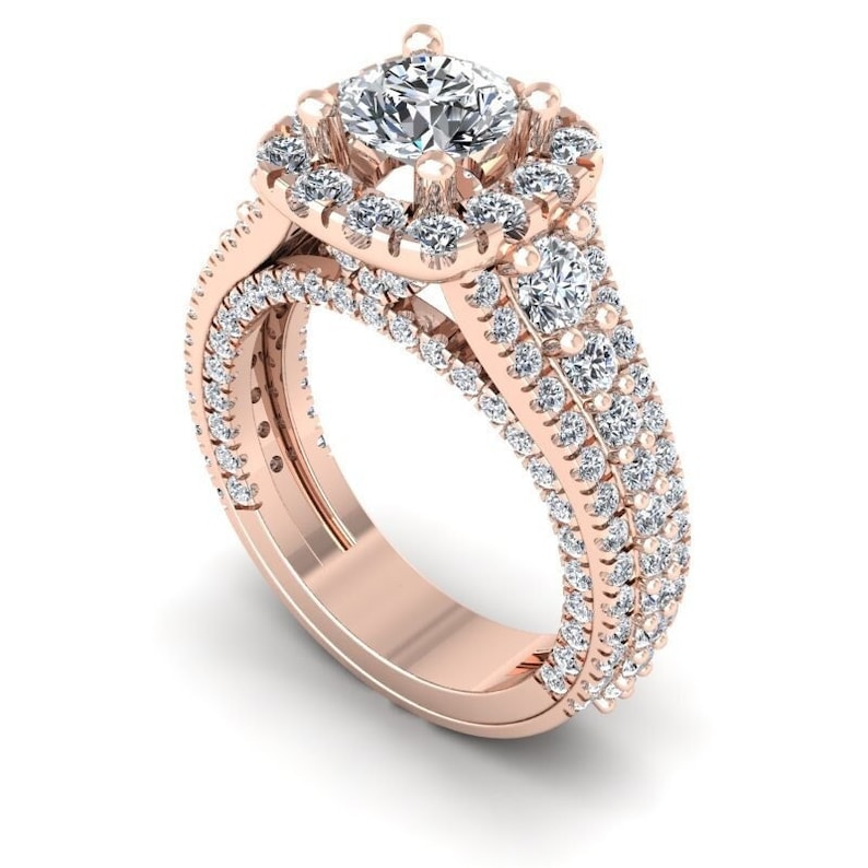May include: A rose gold engagement ring with a square-shaped center diamond surrounded by a halo of smaller diamonds. The band is adorned with a double row of pave-set diamonds.