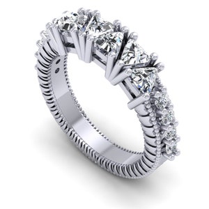 May include: A silver band ring with a row of five triangular-shaped diamonds. The band is textured and has smaller diamonds set along the sides.