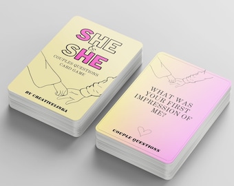Peut inclure: Un jeu de cartes de questions pour couples. Les cartes ont un fond dégradé jaune et rose. Le texte sur les cartes indique "SHE & SHE" et "COUPLES QUESTIONS CARD GAME". L'autre carte indique "WHAT WAS YOUR FIRST IMPRESSION OF ME?"
