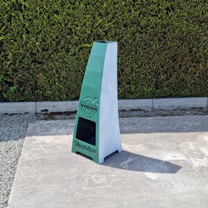 May include: A green metal fire pit with a white top and a Volvo logo. The fire pit is labelled "Sheridan".