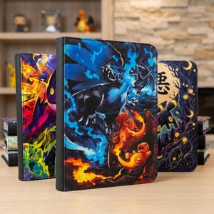 Puede incluir: Tres carpetas rectangulares para tarjetas coleccionables con ilustraciones vibrantes de varias criaturas. La carpeta central muestra una gran figura de dragón azul con llamas, mientras que las laterales muestran patrones abstractos coloridos y una criatura oscura con símbolos lunares.
