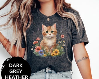 May include: A dark grey heather t-shirt with a graphic of a cute orange kitten sitting in a field of flowers. The text "Dark Grey Heather" is visible in the image.