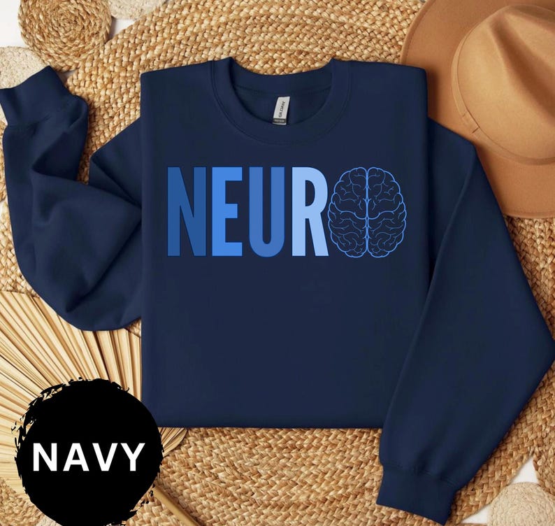 May include: Navy blue sweatshirt with the word "NEURO" in gradient blue letters and a brain graphic. The word "NAVY" is in a black circle at the bottom left. The sweatshirt is on a woven surface.