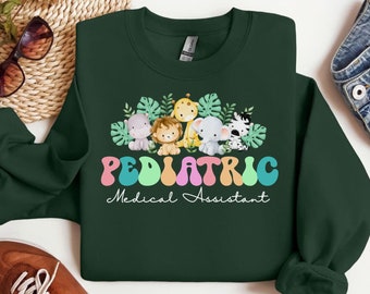 May include: Green sweatshirt with a graphic of a group of cartoon animals in a jungle setting. The text "Pediatric Medical Assistant" is printed below the animals.