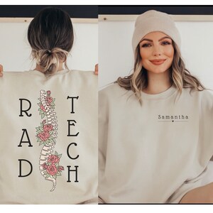 May include: A beige sweatshirt with a floral spine graphic and the text "RAD TECH" on the back. The front of the sweatshirt has the name "Samantha" with a small heart.