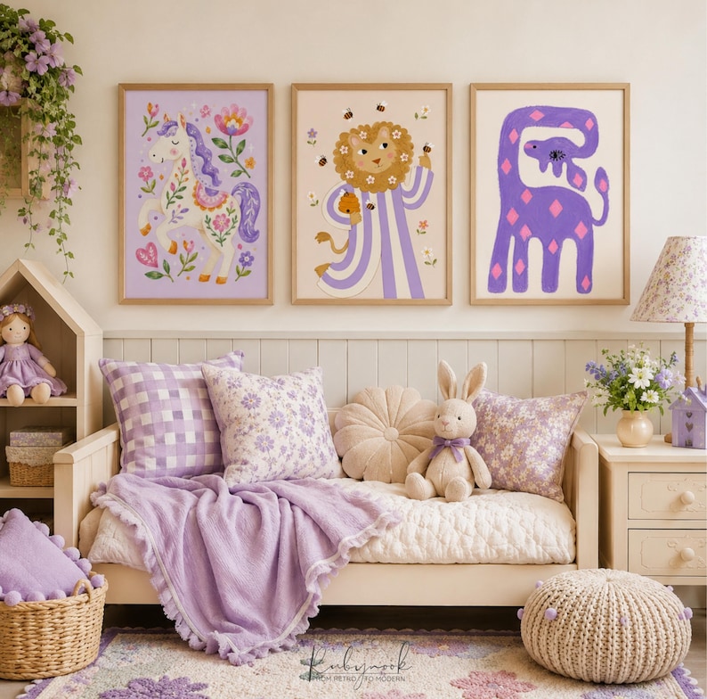 K&ouml;nnte beinhalten: Drei gerahmte Wandbilder mit einem wei&szlig;en Einhorn mit Blumenmustern, einem L&ouml;wen im gestreiften Gewand mit Bienen und einer violetten Giraffe. Die Bilder h&auml;ngen &uuml;ber einem Tagesbett mit lavendelfarbenen Kissen, einer Decke und einem Stoffhasen.