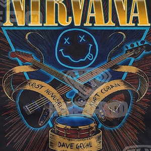 May include: A black t-shirt featuring a gold "NIRVANA" logo and a blue smiley face with X's for eyes. Two guitars are crossed behind the smiley face, with the names "KRIST NOVOSELIC" and "KURT COBAIN" on the guitar straps. A drum is at the bottom with the name "DAVE GROHL" on it.