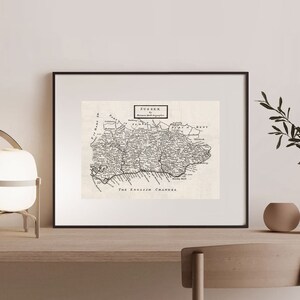 Könnte beinhalten: Eine antike Schwarzweißkarte von Sussex, England, mit dem Titel "SUSSEX" und dem Text "Roman and Saxon Geography" in einem Kasten oben. Die Karte zeigt den Ärmelkanal unten und die Grafschaft Kent im Osten.