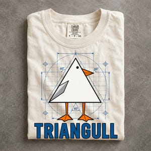 May include: A cream-colored t-shirt featuring a graphic of a white triangular bird with an orange beak and feet, a grey wing, and a black eye. The bird is set against a blue technical blueprint grid with 60-degree angle markings. The text TRIANGULL is printed in blue below the graphic.