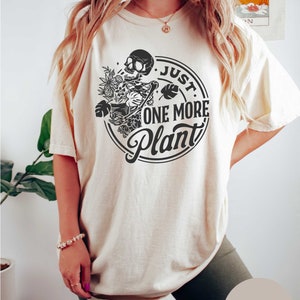 a woman wearing a t - shirt that says just one more planet