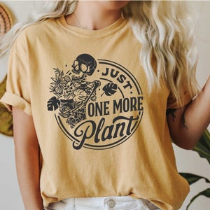a woman wearing a t - shirt that says just one more plant