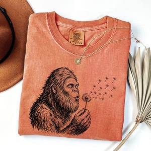Sasquatch Dandelion Shirt Bigfoot Cryptid Hunter Tee Forest Mystery Clothing