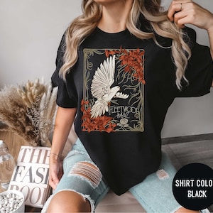 a woman wearing a black t - shirt with a picture of a bird on it