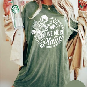 a woman in a green shirt holding a starbucks cup