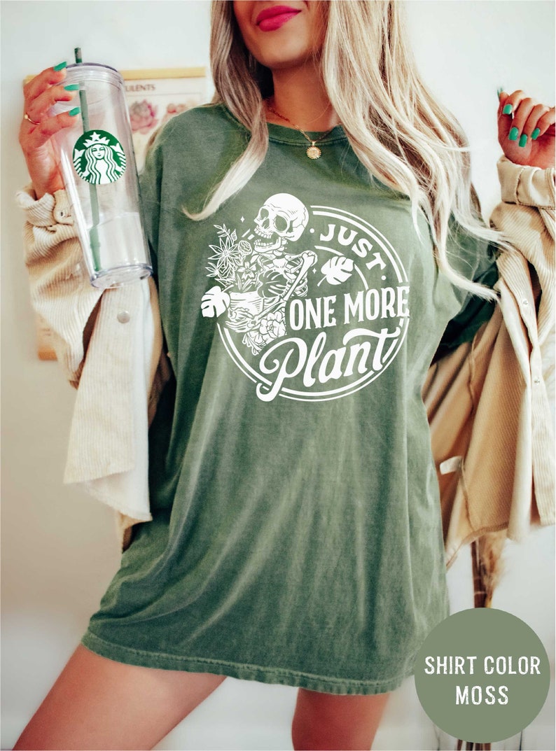 a woman in a green shirt holding a starbucks cup