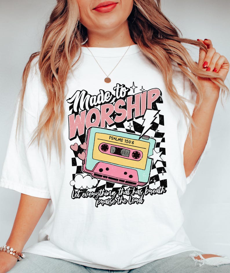 Puede incluir: Camiseta blanca con un gr&aacute;fico de cinta de casete rosa, azul y amarilla. El texto "Made to Worship" est&aacute; por encima de la cinta y "Psalms 150:6" est&aacute; en la cinta. El texto "Let everything that has breath praise the Lord" est&aacute; debajo de la cinta.