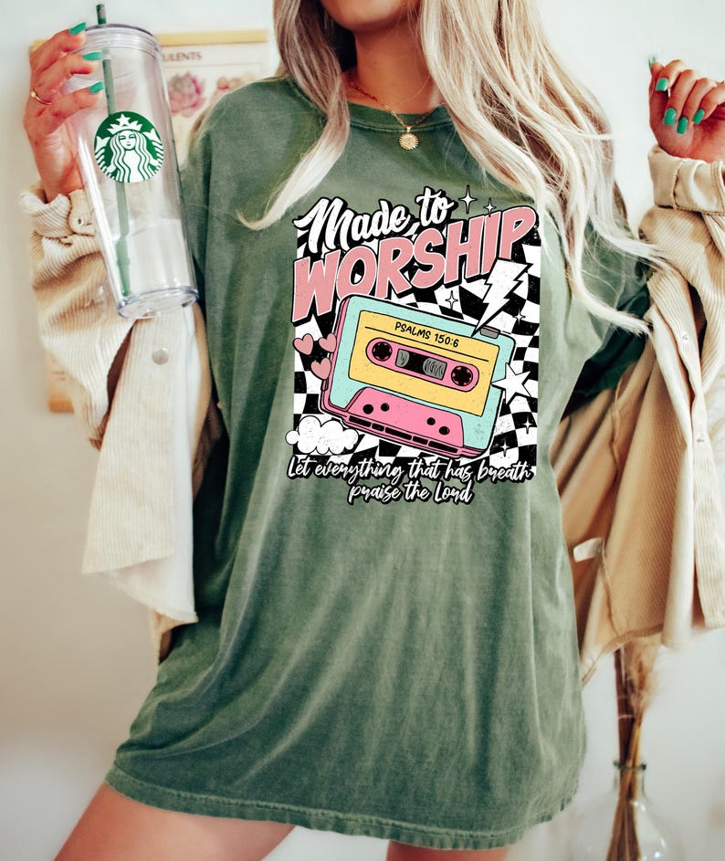 Puede incluir: Camiseta verde con un gr&aacute;fico de casete retro y el texto "Made to Worship" y "Psalms 150:6". El texto "Let everything that has breath praise the Lord" est&aacute; debajo de la cinta de casete.