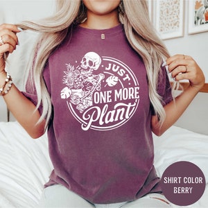 a woman wearing a shirt that says just one more plant