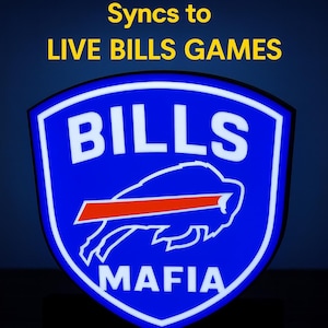 May include: A blue shield-shaped sign with the word "BILLS" in white, a buffalo graphic, and the text "MAFIA" in white. The sign also has the text "Syncs to LIVE BILLS GAMES" in yellow.