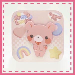 Peut inclure: &Eacute;pingle en &eacute;mail rose avec un ours de dessin anim&eacute;, un c&oelig;ur, un arc-en-ciel, une &eacute;toile et un croissant de lune. Le texte "Froof Loops" et "Enamel Pin" est &eacute;galement pr&eacute;sent.