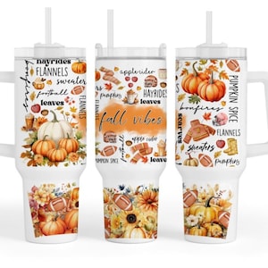 May include: White tumbler with a handle, straw, and fall-themed graphics. The design includes pumpkins, footballs, leaves, and text like "Fall Vibes," "Hayrides," and "Flannels." The bottom features a floral and pumpkin design.