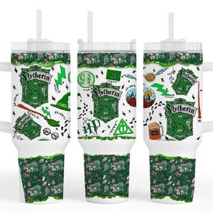 May include: White tumbler with a handle and a straw, featuring a green and white Slytherin design. The design includes the Slytherin crest, lightning bolts, and other Harry Potter-themed graphics. The bottom and top of the tumbler have a green pattern.