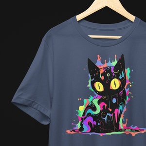 May include: A dark blue t-shirt with a black cat graphic. The cat is surrounded by colorful paint splatters in shades of pink, purple, green, yellow, and blue.