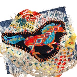 May include: A fabric patch featuring a running horse silhouette in red, orange, and turquoise patterns, stitched onto a black background. The patch is surrounded by various fabric scraps, including denim and patterned textiles, with decorative stitching.