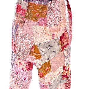 May include: Patchwork trousers in a variety of floral and patterned fabrics. The trousers feature a mix of pinks, reds, and browns, with a gathered waistband. The design is a mix of vintage and bohemian styles.