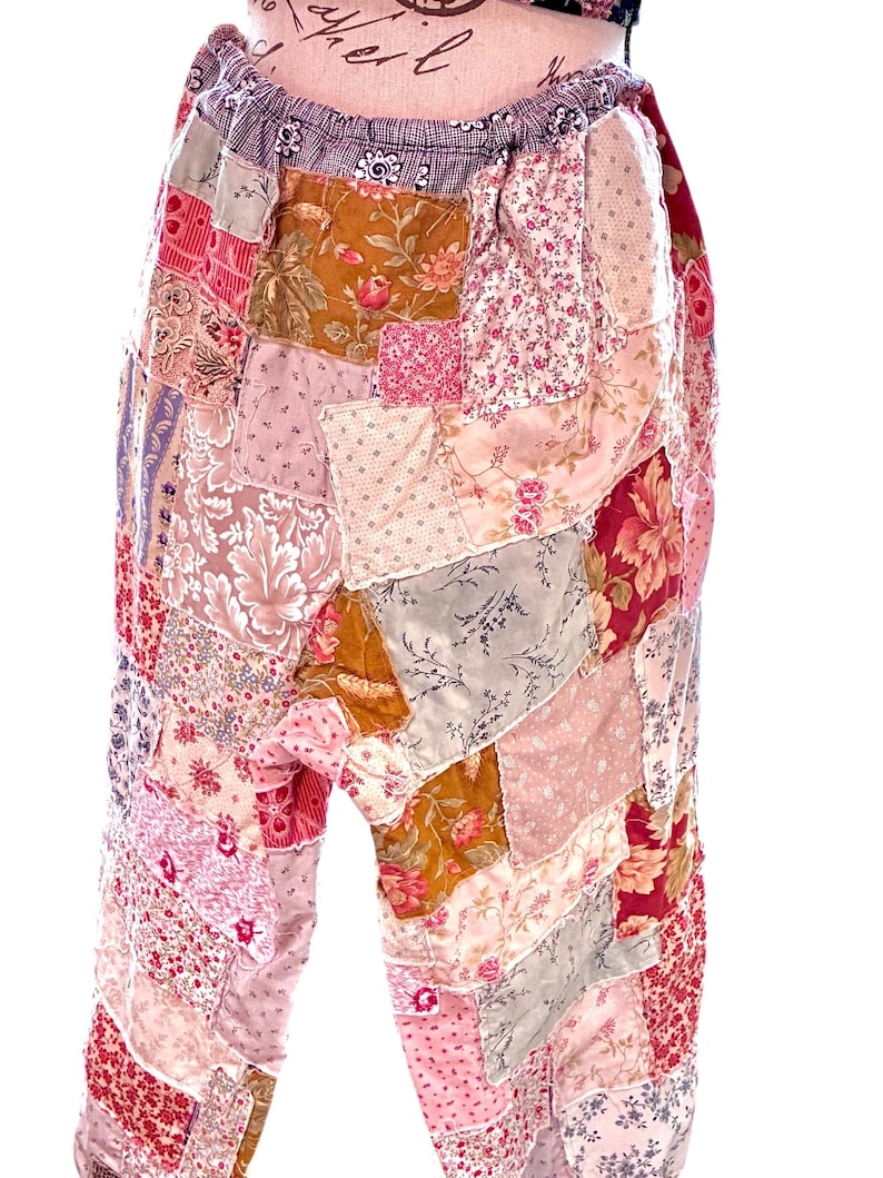 May include: Patchwork trousers in a variety of floral and patterned fabrics. The trousers feature a mix of pinks, reds, and browns, with a gathered waistband. The design is a mix of vintage and bohemian styles.