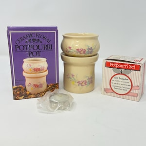 May include: A white ceramic mug with a black handle and the text "But First, Coffee" in a handwritten style. The mug is on a white surface. The mug is approximately 4 inches tall.