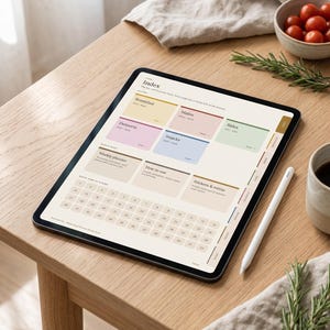 May include: A digital tablet displaying a recipe planner interface with an index featuring sections for Breakfast, Mains, Sides, Desserts, and Snacks, alongside a weekly planner, how-to guide, and a numbered calendar grid for navigation.